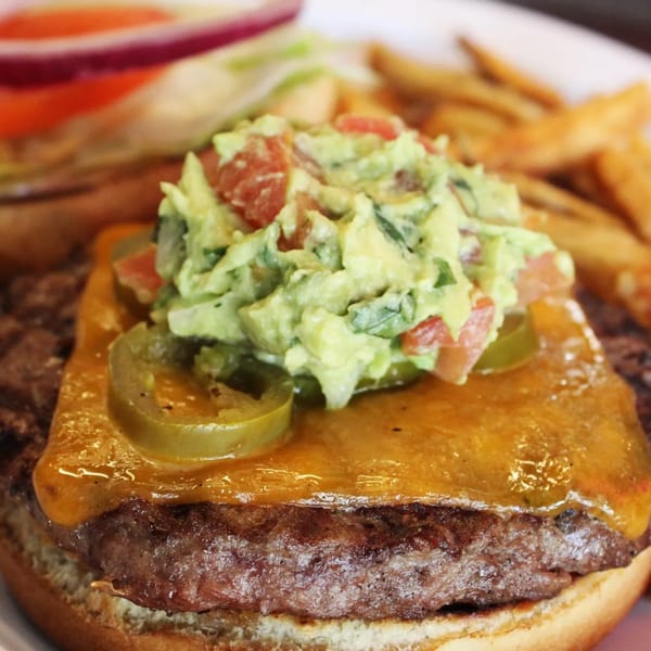 Gio's Bar & Grill burger with melted cheese, guacamole, jalapeños, and fries.