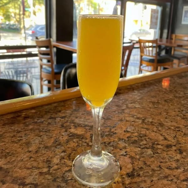 A mimosa in a champagne flute on a granite bar top at Gio's Bar & Grill.