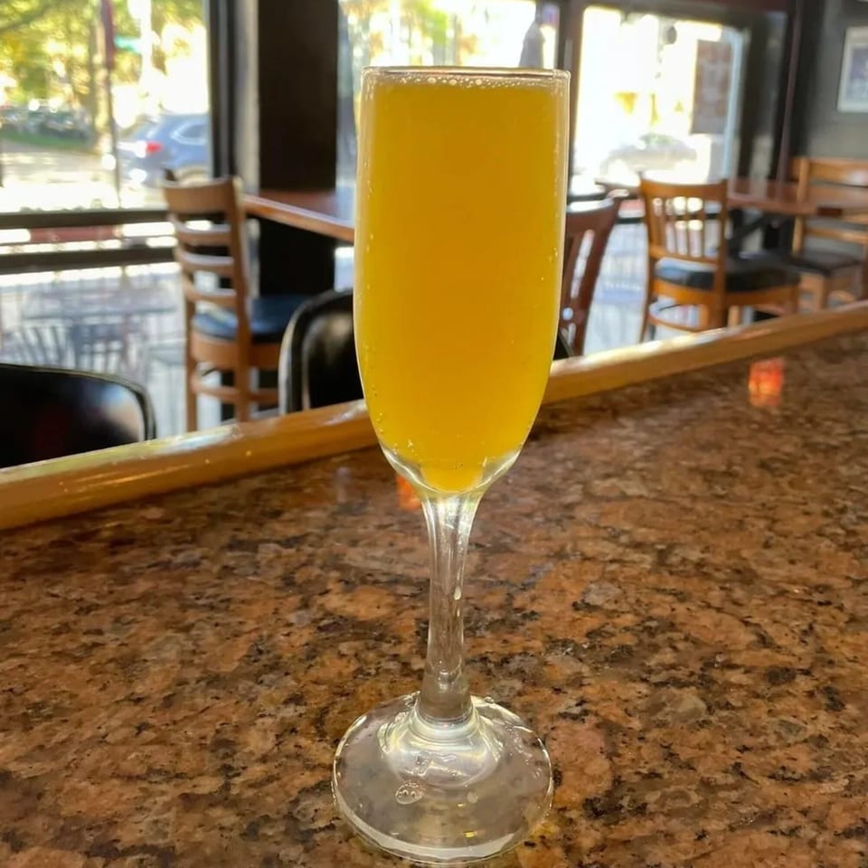 A mimosa in a champagne flute on a granite bar top at Gio's Bar & Grill.